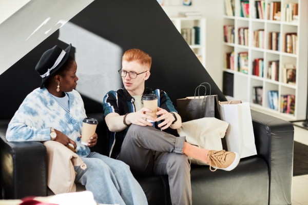 sala love seat; dos personas tomando un café mientras están platicando