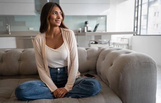 Sofá individual; una chica con blusa blanca sentada en forma de mariposa